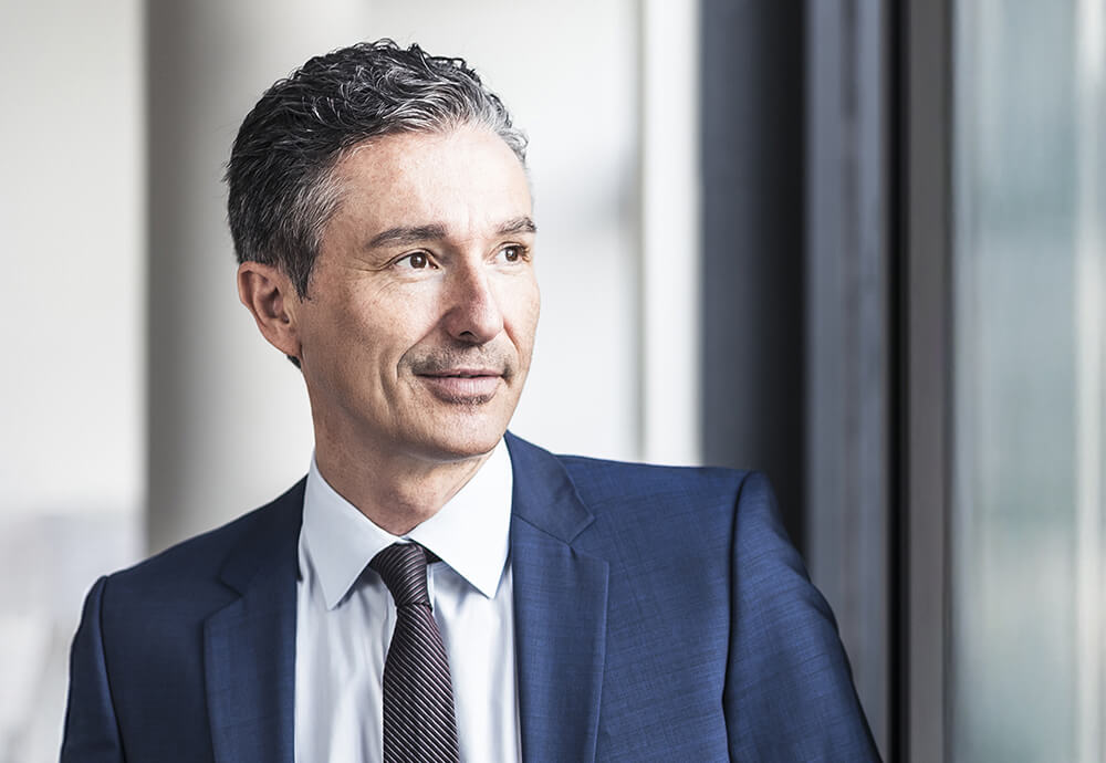 Businessman looking confidently out the window – partnership and growth through professional distribution services.