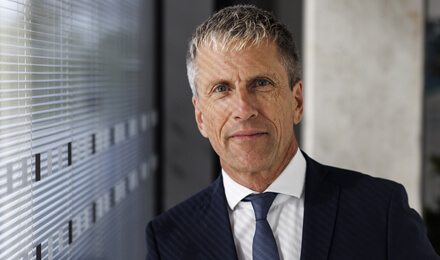 Geschäftsmann in moderner Büroarchitektur – Analyse und Reporting mit dem Fonds-Tool IP Performance.