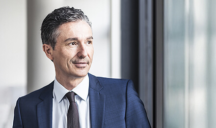 Geschäftsmann zwischen modernen Gebäudefassaden – professionelles Risikomanagement mit dem Fonds-Tool IP Risk.